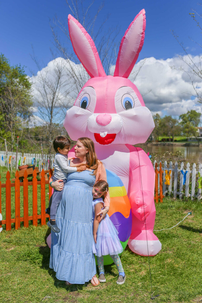 Family posing with giant Easter bunny inflatable at the River Fox Easter Train.