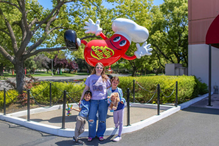 Family posing in front of the giant Jelly Belly mascot statue outside the Jelly Belly Factory in Fairfield, California.