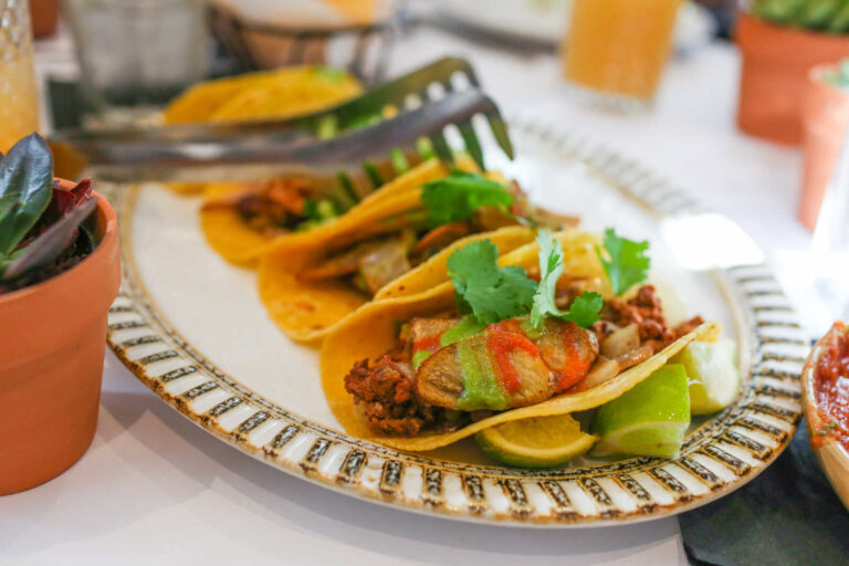 Street-style tacos at Zocalo served with seasoned meat, grilled vegetables, fresh cilantro, and lime wedges.
