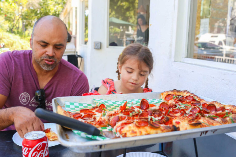A family enjoys pepperoni pizza on the outdoor patio at Pizzasaurus Rex in Midtown Sacramento.
