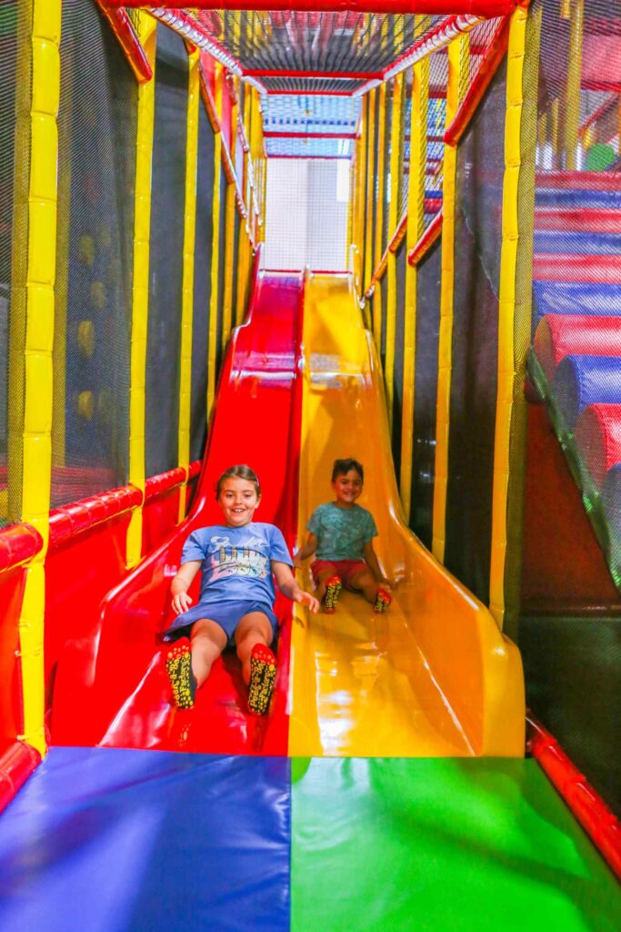 Kids sliding at Peek-a-Boo Factory indoor playground in Rancho Cordova.